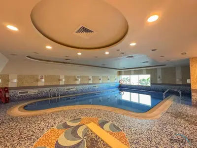 a swimming pool in a large building with a swimming pool at Modern 1BR Apartment in Elite Residences, Dubai Marina by Deluxe Holiday Homes in Dubai