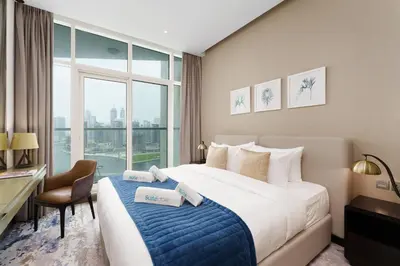 a hotel room with a bed and a desk and a window at Your Dream Home in Damac Maison Prive by Suiteable in Dubai