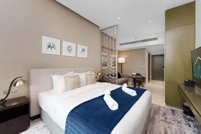 a bedroom with a large bed with a blue blanket at Your Dream Home in Damac Maison Prive by Suiteable in Dubai
