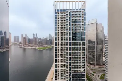 a tall building next to a body of water at Your Dream Home in Damac Maison Prive by Suiteable in Dubai