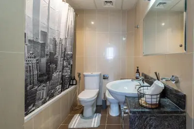 a bathroom with a white toilet and a sink at Newly renovated cosy studio in Dubai