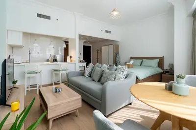 a living room with a couch and a table at Newly renovated cosy studio in Dubai
