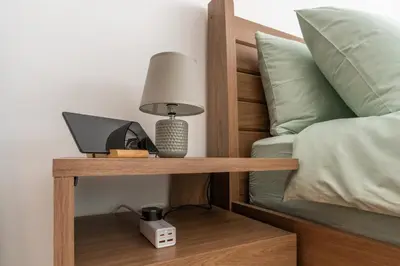a bed with a desk with a laptop and a lamp at Newly renovated cosy studio in Dubai
