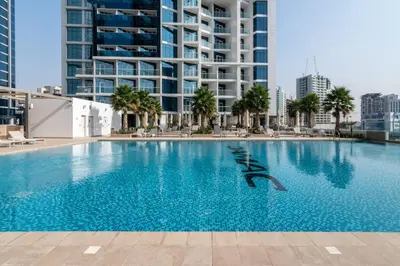 a large swimming pool in a city with tall buildings at GuestReady - Modern studio with Dubai Canal View in Dubai
