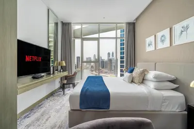 a hotel room with a king sized bed and a tv at GuestReady - Stylish studio with Dubai Canal view in Dubai