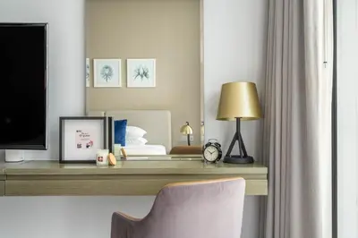 a bedroom with a desk with a tv and a bed at GuestReady - Stylish studio with Dubai Canal view in Dubai