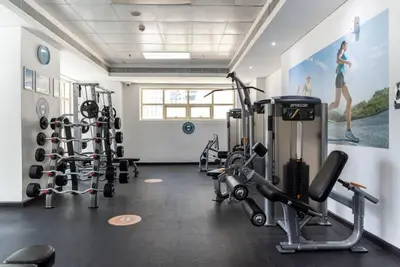 a gym with several treadmills and weights in a room at Stylish 1BR Apartment with City View Balcony Pool and Parking in Dubai
