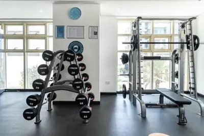 a gym with two treadmills and a treadmill at Stylish 1BR Apartment with City View Balcony Pool and Parking in Dubai