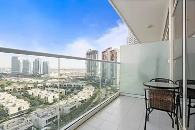 a balcony with a table and chairs and a view of a city at Cozy Studio in Damac Hills in Dubai