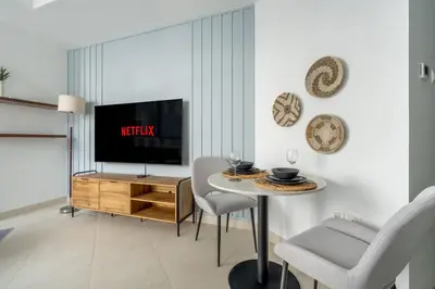 a living room with a tv and a table and chairs at GuestReady - A Sanctuary Above the Clouds in Dubai