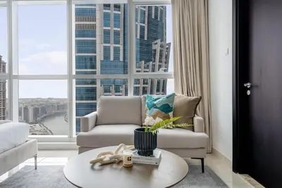 a living room with a couch and a chair and a large window at GuestReady - A Sanctuary Above the Clouds in Dubai