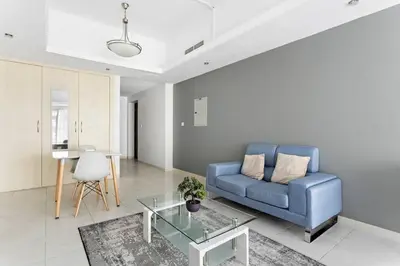 a living room with a blue couch and a table at Stylish Studio in Prime Location in Dubai