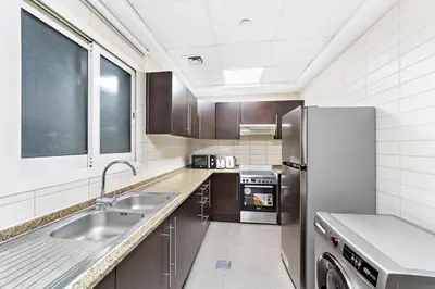 a kitchen with a sink and a refrigerator at Stylish Studio in Prime Location in Dubai