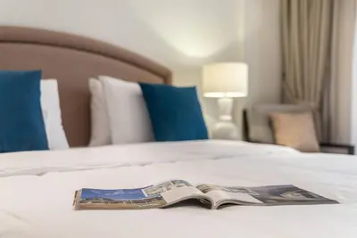 an open book on a bed with a hotel at FIRST CLASS 1BR in Royale Apartment on the Palm in Dubai