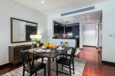 a dining room with a table and chairs and a kitchen at FIRST CLASS 1BR in Royale Apartment on the Palm in Dubai