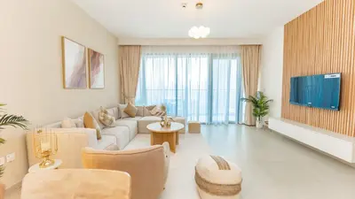 a living room with a couch and a tv at Burj Khalifa view with Grass Turf Balcony-Downtown by Tanami Holiday Homes in Dubai