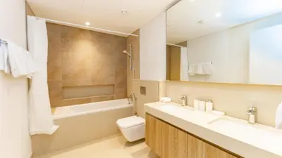 a bathroom with a tub and a toilet and a sink at Burj Khalifa view with Grass Turf Balcony-Downtown by Tanami Holiday Homes in Dubai