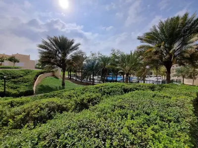 a park with palm trees and bushes at YALLA REMRAAM in Dubai