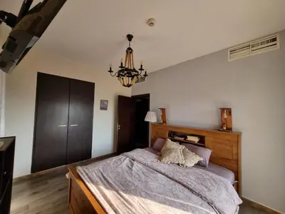 a bedroom with a large bed and a chandelier at YALLA REMRAAM in Dubai