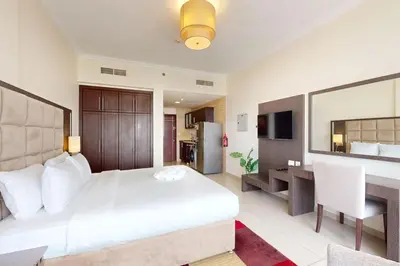 a bedroom with a large white bed and a desk at Siraj Tower - Colourful Studio in Dubai