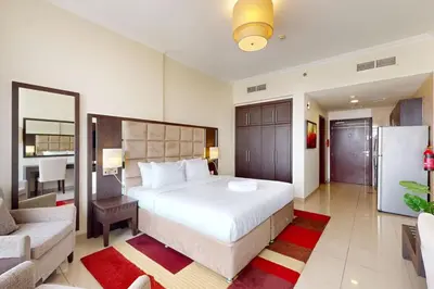 a bedroom with a large white bed and a couch at Siraj Tower - Colourful Studio in Dubai