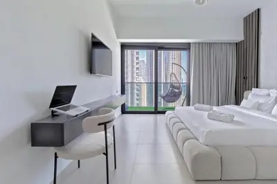 a hotel room with a bed and a desk with a computer at Luxurious 4BR Apartment w/ Prime Burj Khalifa View in Dubai