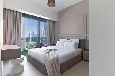 a bedroom with a large bed and a large window at Luxurious 4BR Apartment w/ Prime Burj Khalifa View in Dubai