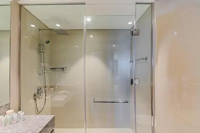 a shower with a glass door in a bathroom at Luxurious 4BR Apartment w/ Prime Burj Khalifa View in Dubai