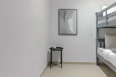 a white bedroom with a black table and a mirror at Luxurious 4BR Apartment w/ Prime Burj Khalifa View in Dubai