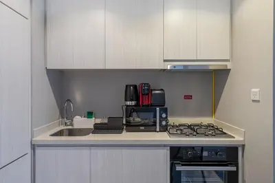 a kitchen with a sink and a stove top oven at Modern Brand New 1 BR Apartment in ZADA Tower in Dubai
