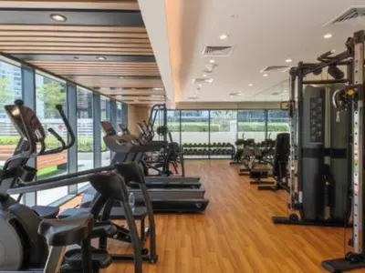 a gym with a bunch of treadmills and machines at Modern Brand New 1 BR Apartment in ZADA Tower in Dubai