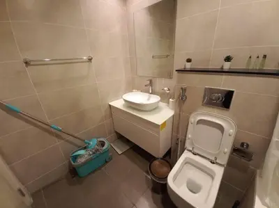 a small bathroom with a toilet and a sink at Furnished Studio in Damac Hills in Dubai