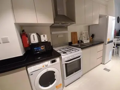a kitchen with a stove and a washing machine at Furnished Studio in Damac Hills in Dubai