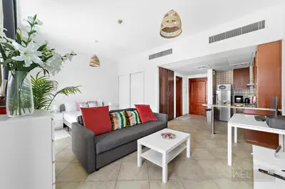 a living room with a couch and a table at WelHome - Stylish Studio with Park Views in Regent House 2 in Dubai