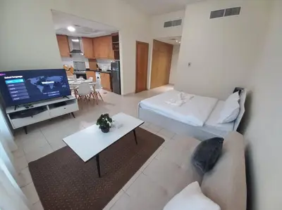 a living room with a couch and a tv at Cozy Studio in Discovery Gardens in Dubai