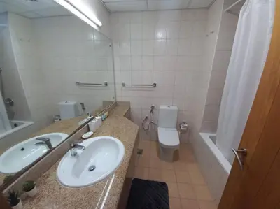 a bathroom with a sink and a toilet and a mirror at Cozy Studio in Discovery Gardens in Dubai