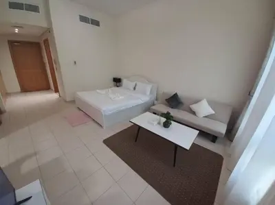 a living room with a white couch and a table at Cozy Studio in Discovery Gardens in Dubai