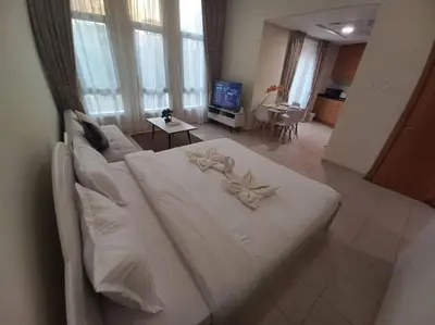 a large white bed in a room with a television at Cozy Studio in Discovery Gardens in Dubai