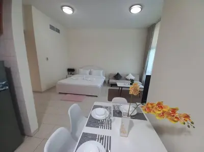 a living room with a table and a couch at Cozy Studio in Discovery Gardens in Dubai