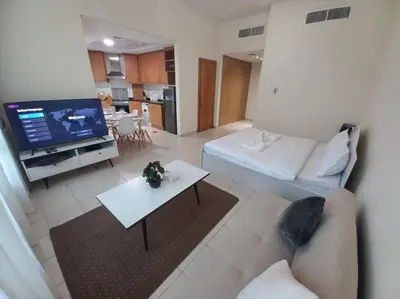 a living room with a couch and a tv at Cozy Studio in Discovery Gardens in Dubai