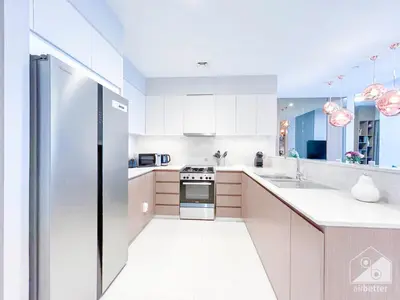 a kitchen with white cabinets and a stainless steel refrigerator at Spacious 3.5 Bedroom Apartment in Burj Royale in Dubai