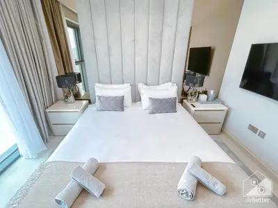 a bedroom with a large white bed with two pillows at Spacious 3.5 Bedroom Apartment in Burj Royale in Dubai