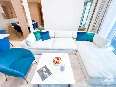a living room with a white couch and blue pillows at Spacious 3.5 Bedroom Apartment in Burj Royale in Dubai