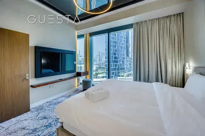 a bedroom with a large white bed and a tv at 52 I 42 Tower by Emaar, Dubai Marina in Dubai