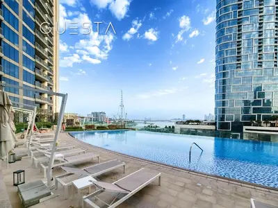a swimming pool with lounge chairs and buildings at 52 I 42 Tower by Emaar, Dubai Marina in Dubai