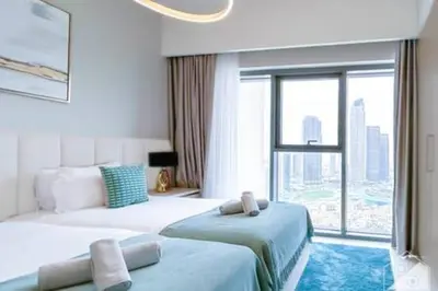 a hotel room with two beds and a large window at Luxury Burj Royale 4Bed Balcony Burj Khalifa View in Dubai