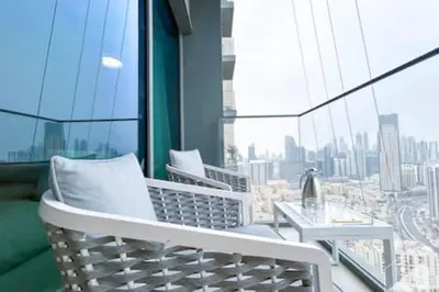 a balcony with two chairs and a table on a building at Luxury Burj Royale 4Bed Balcony Burj Khalifa View in Dubai
