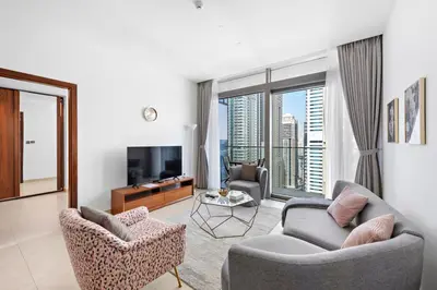 a living room with two chairs and a television at Stylish 1 BR in Dubai Marina in Dubai