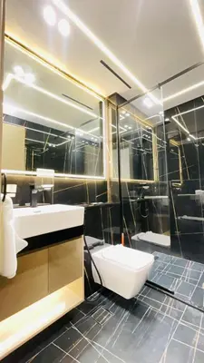 a bathroom with a sink and a toilet and a mirror at Luxe 1BR 15mins-Beach Best Infinity Pool -Jumeirah Village Circle, JVC ,Dubai in Dubai