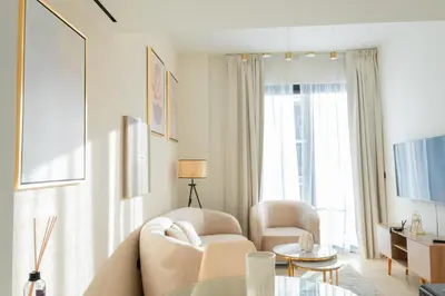 a living room with a couch and a table at Luxe 1BR 15mins-Beach Best Infinity Pool -Jumeirah Village Circle, JVC ,Dubai in Dubai